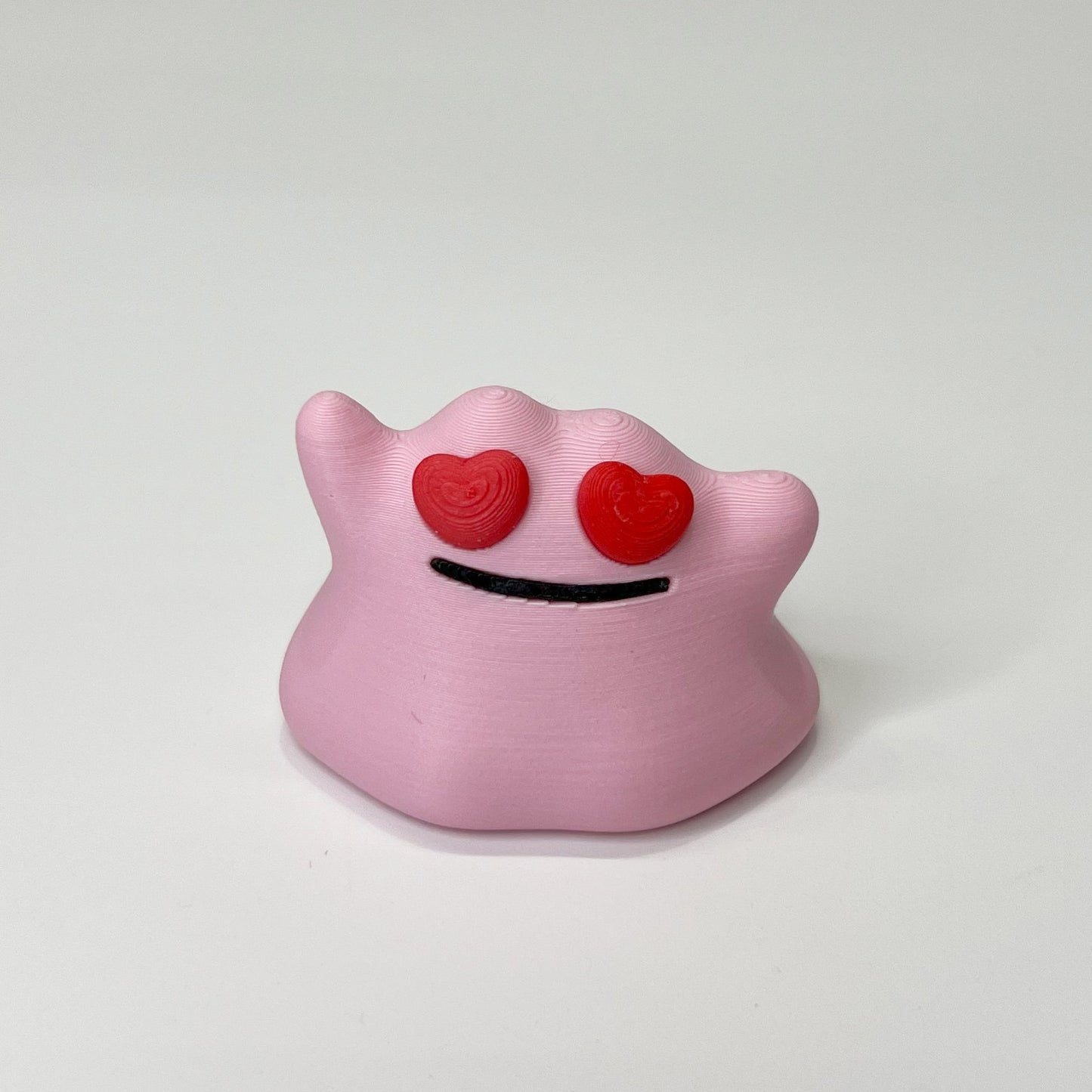 a pink toy with two red hearts on it's eyes